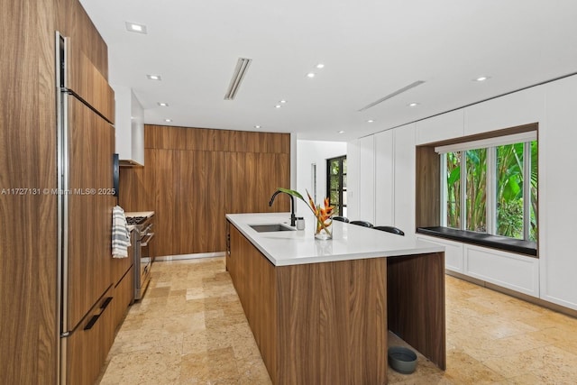 kitchen featuring brown cabinetry, modern cabinets, and a sink