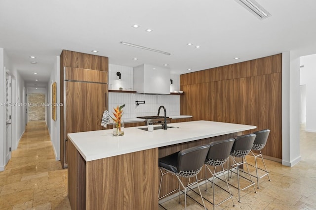 kitchen featuring open shelves, a sink, modern cabinets, brown cabinets, and backsplash