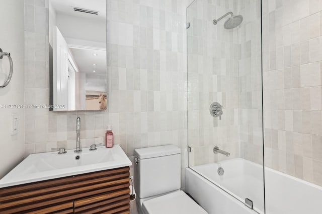 full bathroom featuring vanity, tile walls, tasteful backsplash, and shower / washtub combination