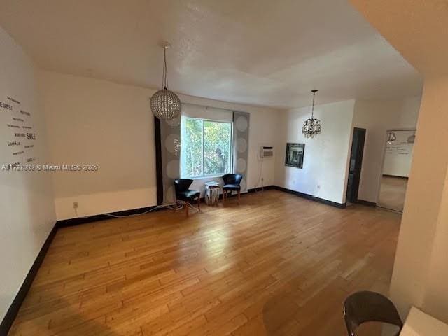 unfurnished living room with hardwood / wood-style floors and a chandelier