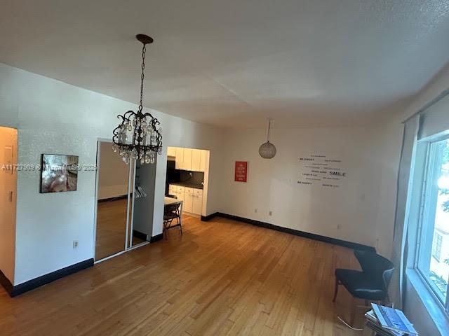 unfurnished dining area featuring dark wood-type flooring and an inviting chandelier