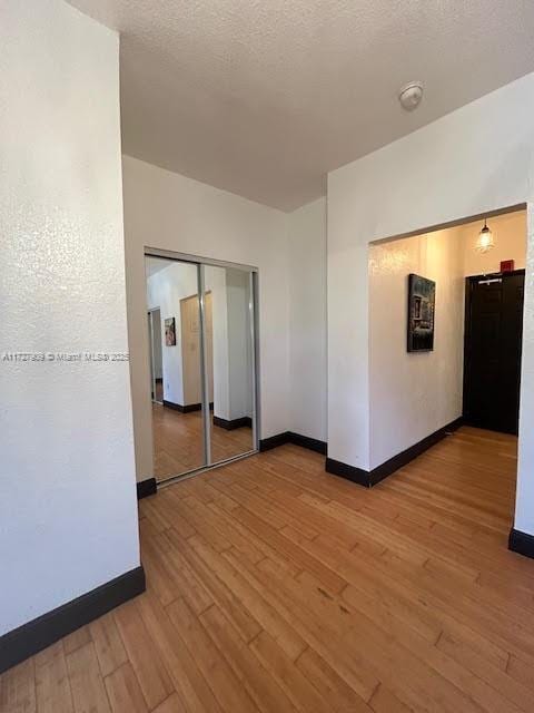 spare room with a textured ceiling and light wood-type flooring