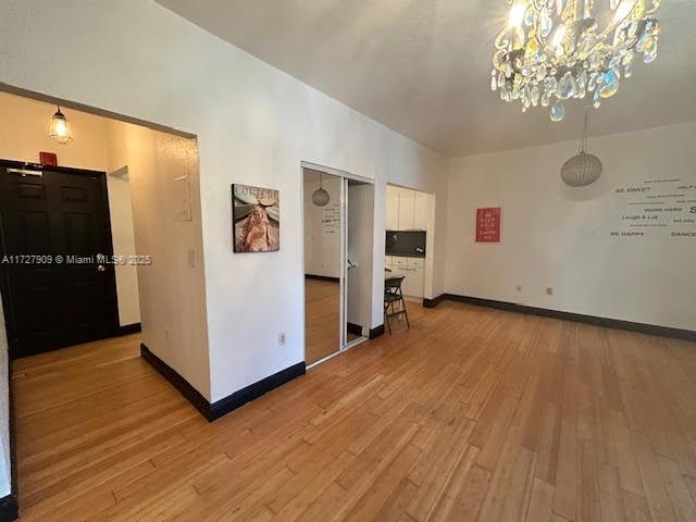 interior space with wood-type flooring and a chandelier