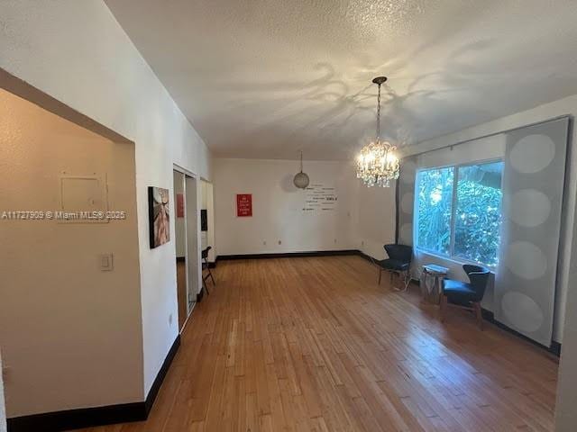 interior space featuring a notable chandelier, a textured ceiling, and hardwood / wood-style flooring