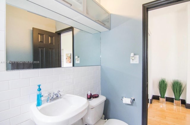 bathroom featuring sink, backsplash, toilet, and hardwood / wood-style floors