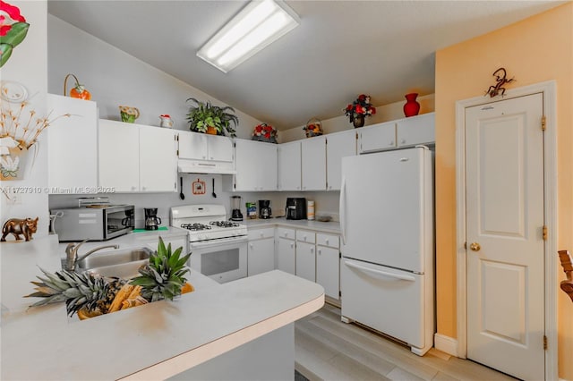 kitchen with lofted ceiling, kitchen peninsula, white appliances, white cabinetry, and light wood-type flooring