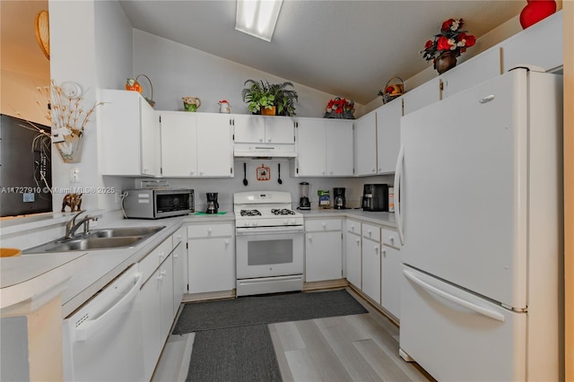 kitchen featuring white cabinetry, sink, white appliances, and vaulted ceiling