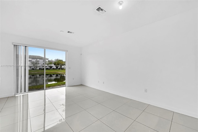 tiled spare room with a water view