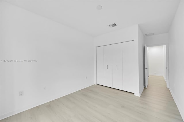 unfurnished bedroom featuring a closet and light hardwood / wood-style flooring