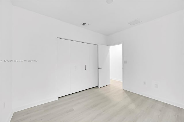 unfurnished bedroom with a closet and light hardwood / wood-style flooring