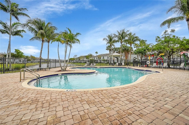 view of swimming pool featuring a playground and a patio