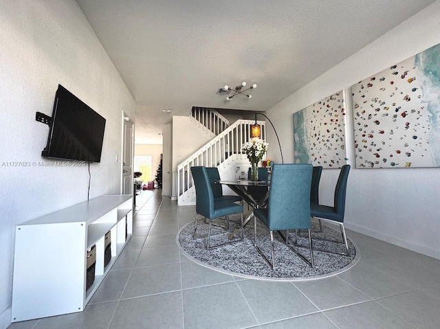 dining space with a textured ceiling and tile patterned floors