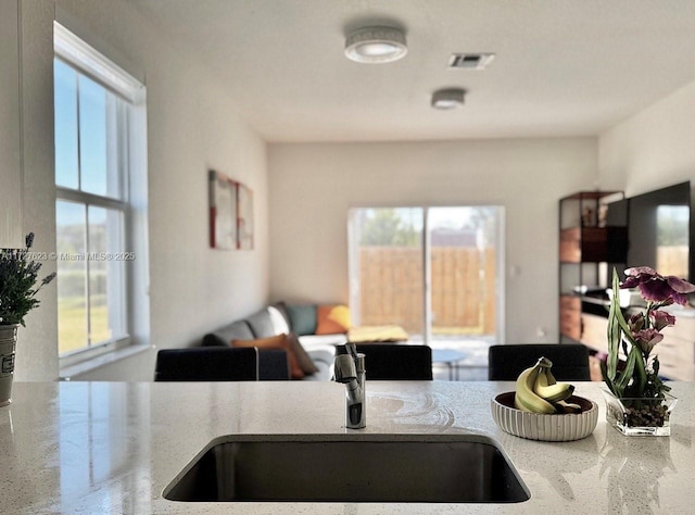 kitchen featuring sink and light stone countertops