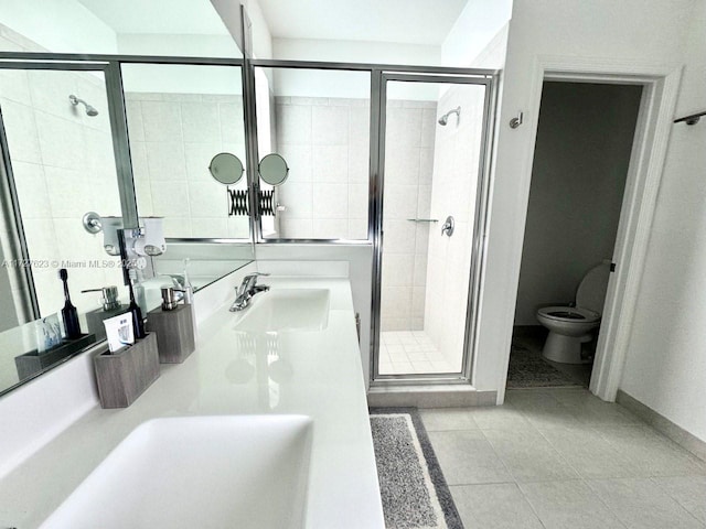 bathroom with a shower with shower door, toilet, vanity, and tile patterned flooring