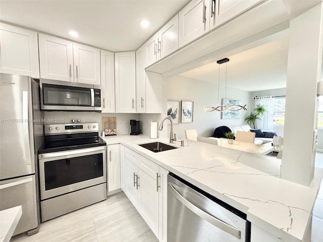 kitchen featuring white cabinetry, sink, kitchen peninsula, and appliances with stainless steel finishes