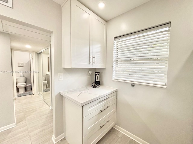 kitchen featuring light stone counters and white cabinets