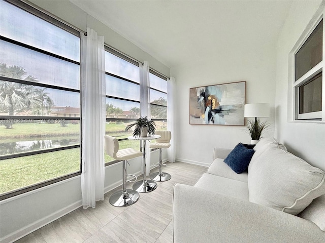 sunroom featuring a water view and a wealth of natural light