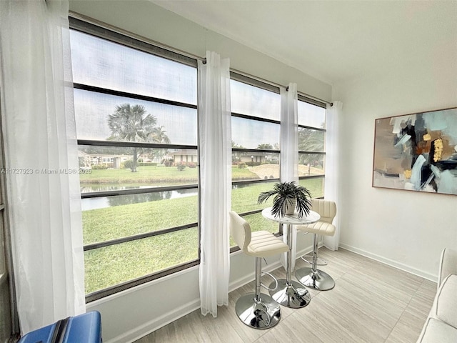 sunroom / solarium featuring a wealth of natural light and a water view