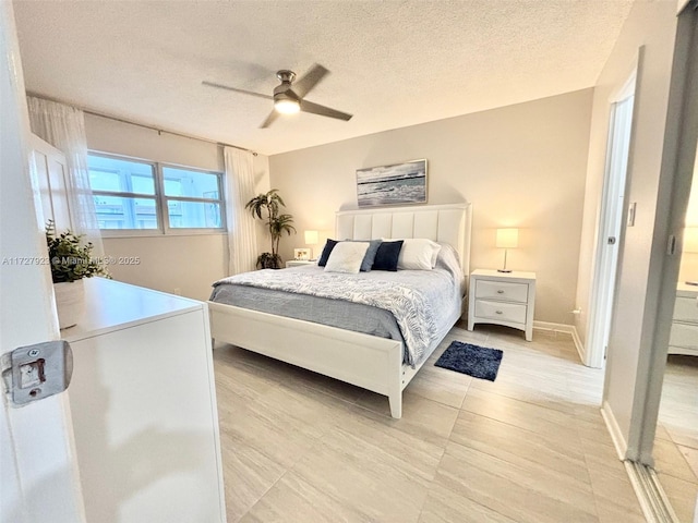 bedroom featuring light tile patterned floors, a textured ceiling, and ceiling fan