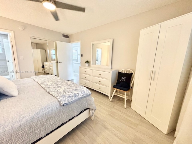 bedroom featuring ensuite bath, light hardwood / wood-style flooring, and ceiling fan