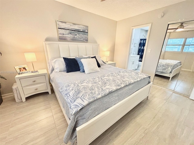 bedroom featuring a walk in closet, ensuite bathroom, a closet, and a textured ceiling