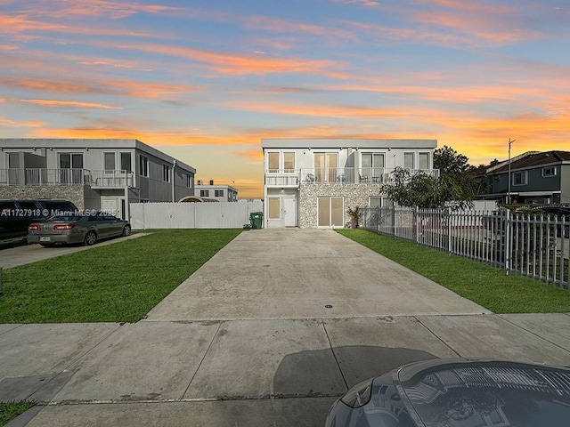 view of front of home with a balcony and a yard