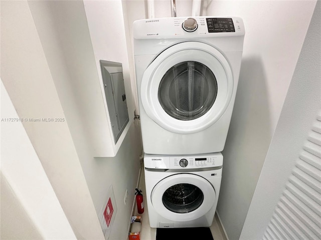 laundry room with stacked washer / drying machine and electric panel