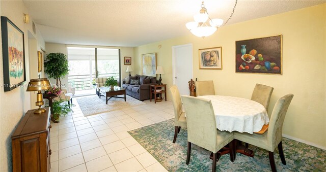 dining room featuring a textured ceiling, an inviting chandelier, light tile patterned floors, and a wall of windows