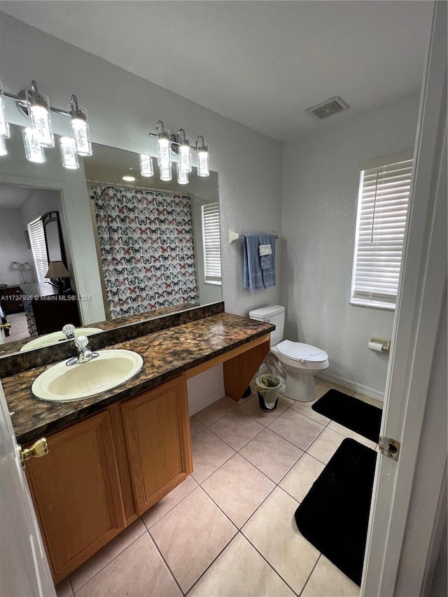 bathroom featuring toilet, vanity, tile patterned flooring, and a shower with curtain