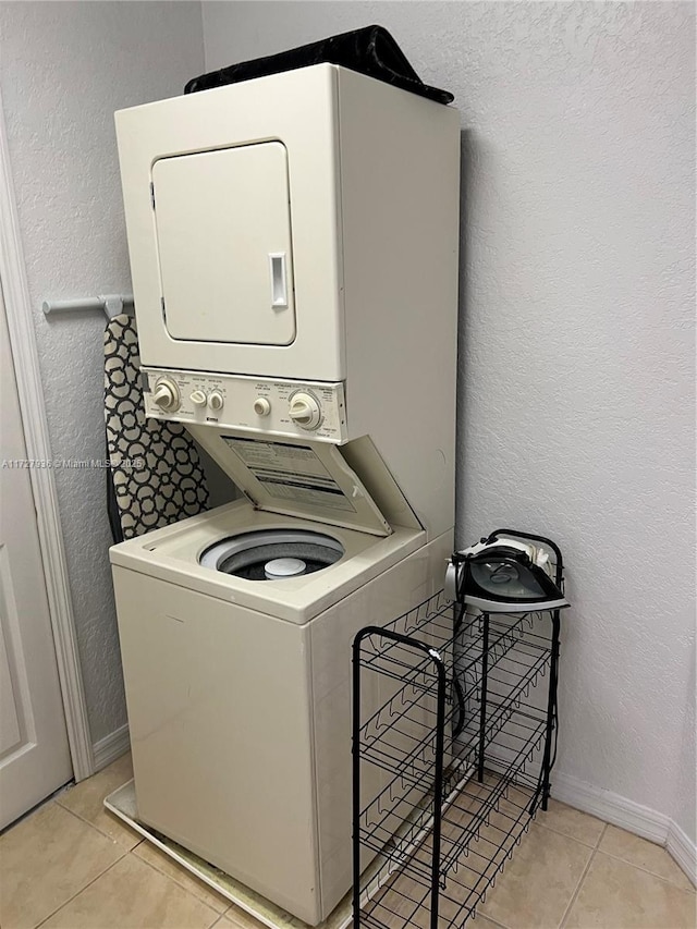 laundry area with light tile patterned floors and stacked washer and dryer