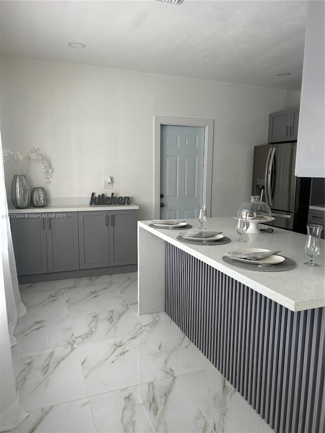 kitchen with stainless steel fridge with ice dispenser and gray cabinets