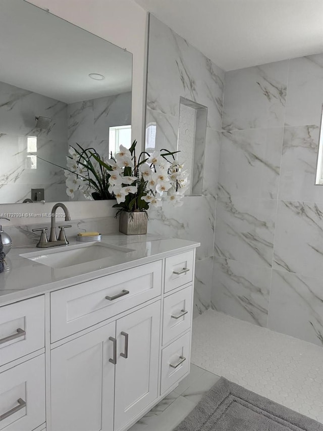 bathroom featuring tiled shower and vanity