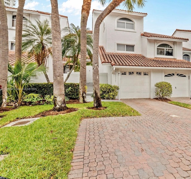 mediterranean / spanish house with a front lawn and a garage