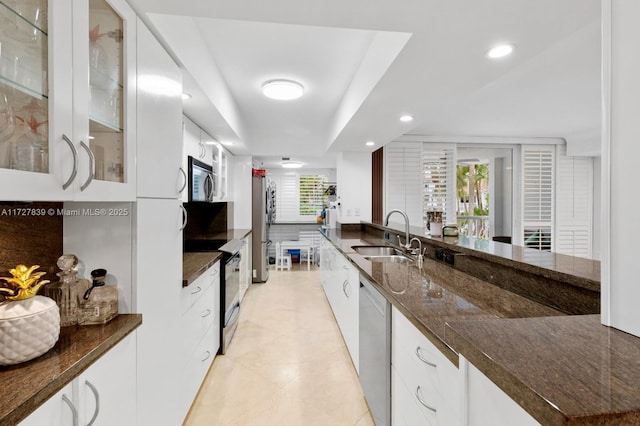 kitchen featuring sink, white cabinets, dark stone counters, and appliances with stainless steel finishes