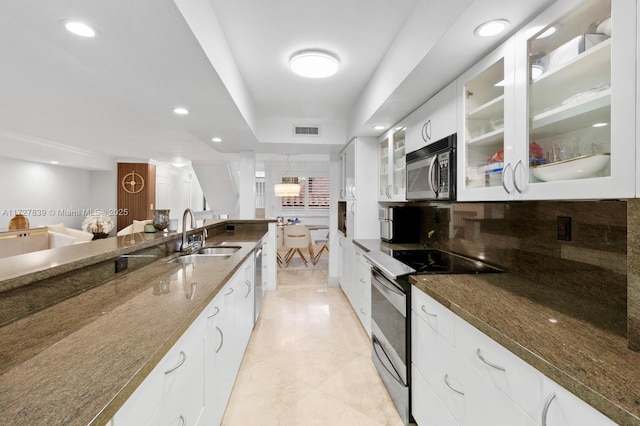 kitchen featuring sink, white cabinetry, stainless steel appliances, and dark stone countertops