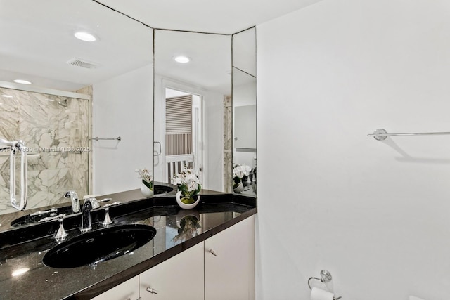 bathroom with walk in shower and vanity