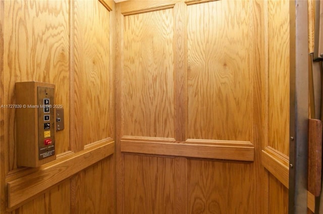 details featuring wooden walls and elevator