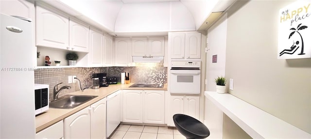 kitchen with white appliances, white cabinetry, decorative backsplash, sink, and light tile patterned floors