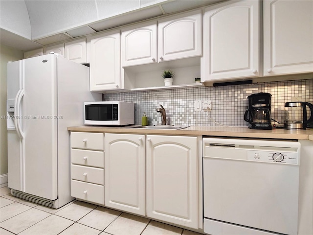 kitchen with white appliances, white cabinetry, decorative backsplash, sink, and light tile patterned floors