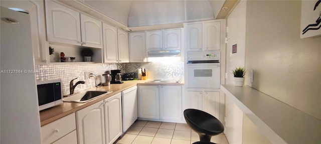 kitchen with tasteful backsplash, sink, white appliances, white cabinetry, and light tile patterned floors