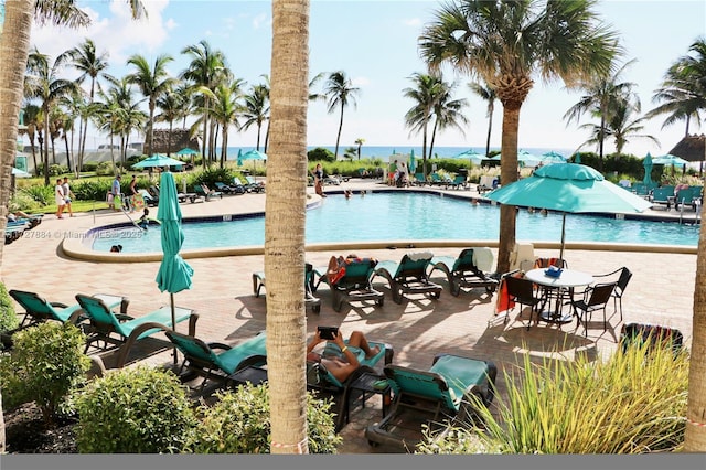 view of swimming pool featuring a patio area and a water view