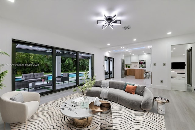 living room featuring a wealth of natural light and light hardwood / wood-style flooring