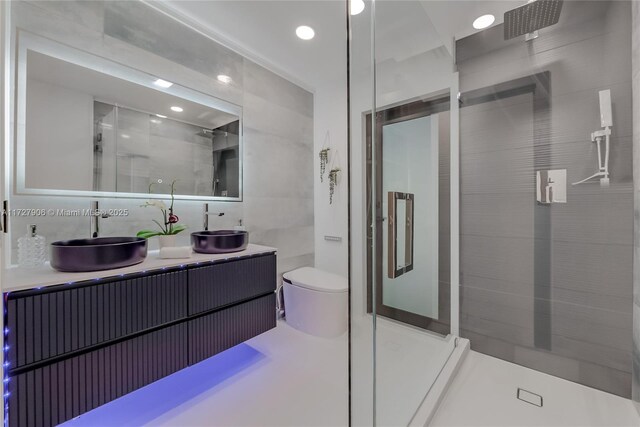 bathroom with tile walls, tasteful backsplash, an enclosed shower, vanity, and toilet