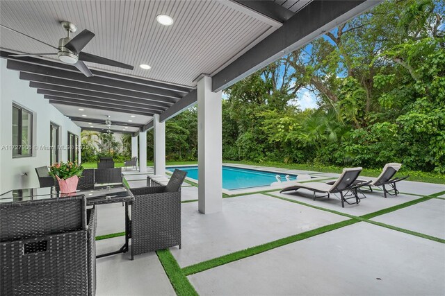 view of pool with exterior kitchen, ceiling fan, and a patio area