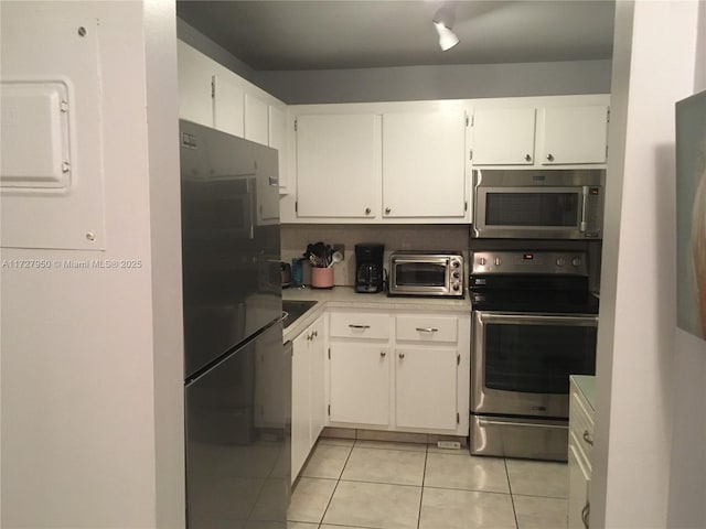 kitchen featuring white cabinets, light tile patterned floors, and appliances with stainless steel finishes