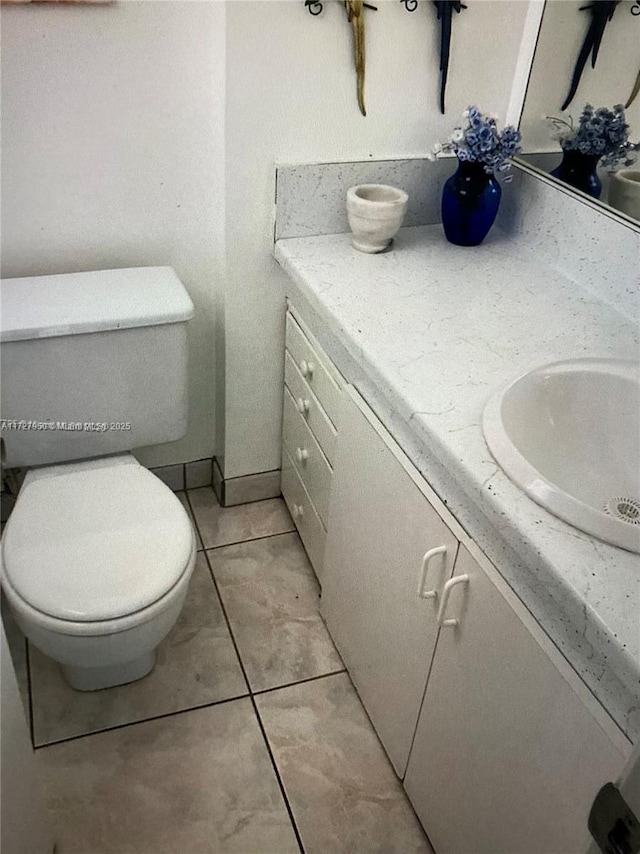 bathroom featuring toilet, vanity, and tile patterned flooring