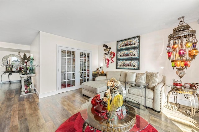 living room with hardwood / wood-style flooring, an inviting chandelier, and french doors