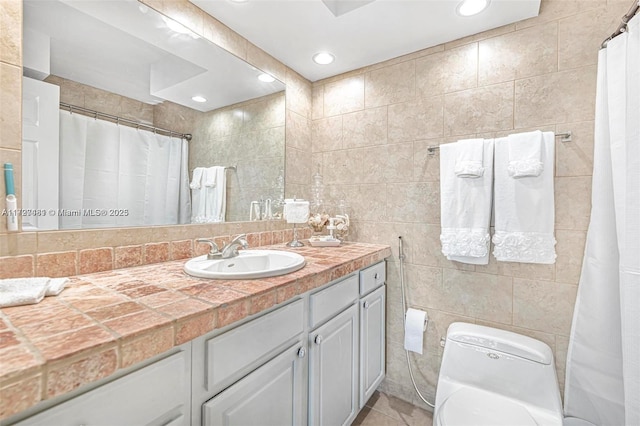 bathroom featuring toilet, vanity, tile walls, and tile patterned flooring