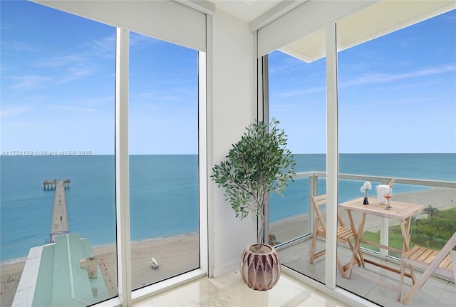 sunroom / solarium with a view of the beach and a water view