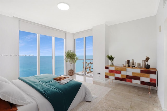 bedroom with a water view, a wall of windows, and access to outside